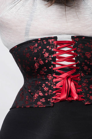 Red Rosebud Coutil black corset features delicate red floral detail. This image shoes the red lacing