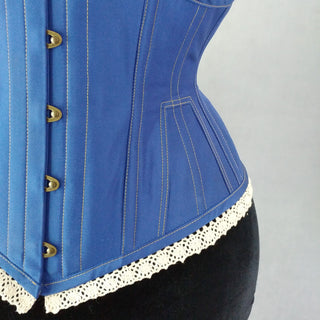 A Bad Button bespoke corset design by Alisha Martin featuring a blue base, contrast stitching and lace edge detailing
