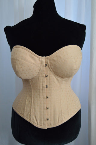 A Bad Button bespoke corset design by Alisha Martin featuring a subtle cream fabric