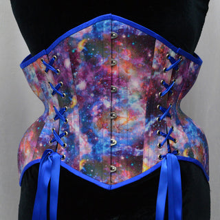 A Bad Button bespoke corset design by Alisha Martin featuring a galaxy print and bright blue lacing and detailing