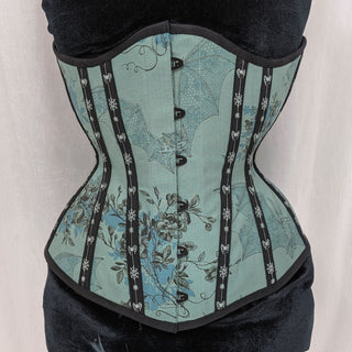 A Bad Button bespoke corset design by Alisha Martin featuring a pale green fabric covered in flowers and bats with black detailing