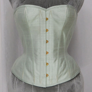 A Bad Button bespoke corset design by Alisha Martin featuring a pale mint green fabric and grey lacing