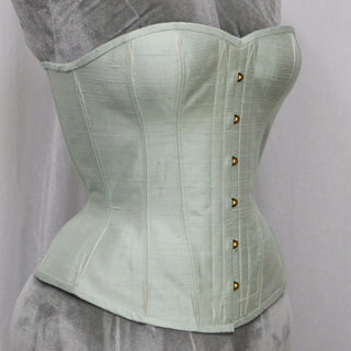 A Bad Button bespoke corset design by Alisha Martin featuring a pale mint green fabric and grey lacing