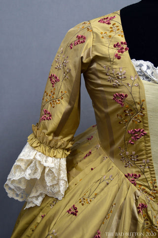 A Bad Button bespoke corset design by Alisha Martin in the form of historical stays and matching mustard gown with floral details