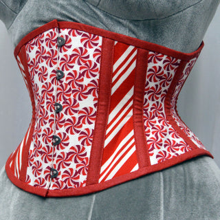 A Bad Button bespoke corset design by Alisha Martin featuring candy peppermint fabric alternated with red and white candy cane fabric