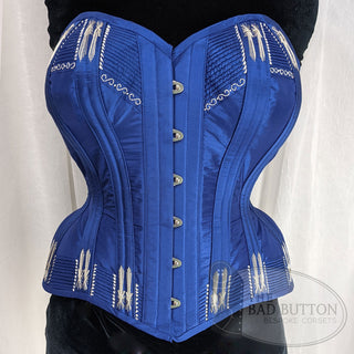 A Bad Button bespoke corset design by Alisha Martin featuring a deep blue base and silver stitch detailing