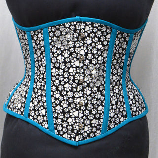 A Bad Button custom corset design by Alisha Martin featuring black and white pawprint fabric and bright blue piping