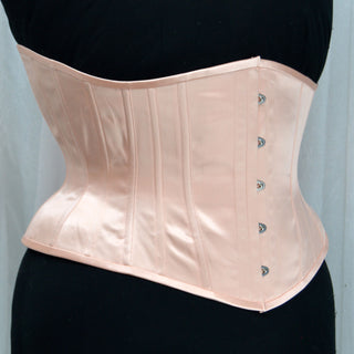A Bad Button custom corset design by Alisha Martin in a delicate light pink color
