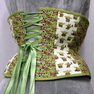A Bad Button custom corset design by Alisha Martin featuring a white fabric with small baby yodas printed onto it