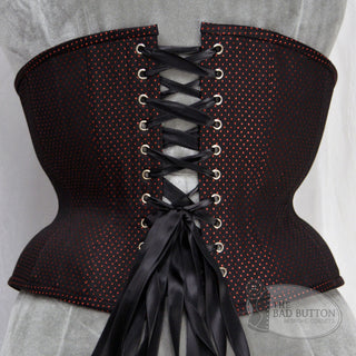 A Bad Button custom corset design by Alisha Martin featuring a black fabric with small red spots