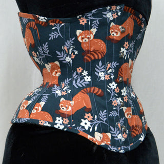 A Bad Button custom corset design by Alisha Martin featuring a fabric with cartoon red pandas and flower motifs