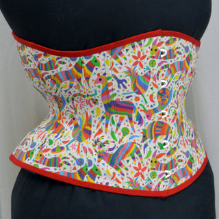 A Bad Button custom corset design by Alisha Martin featuring a white fabric with rainbow animals and confetti with red piping and yellow lacing