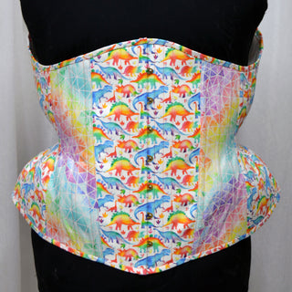 A fully bespoke corset by The Bad Button features rainbow dinosaur designed fabric