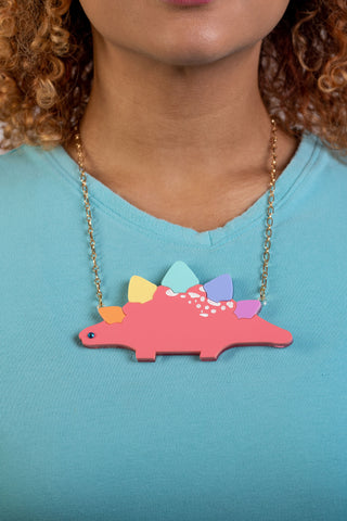 The Bad Button pride collection features a rainbow stegosaurus necklace with gold chain
