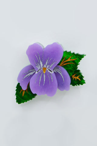 The Bad Button vibrant violet brooch sits on a white backkground